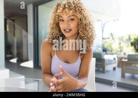 Eine junge Frau lächelt bei einem Videoanruf herzlich zu Hause Stockfoto