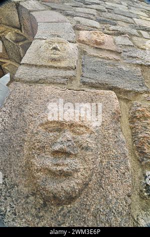 Gravuren und Basreliefs mit grotesken Menschen- und Teufelsmasken an der Wand der Kirche in Inowrocław Stockfoto