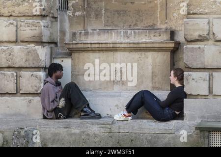 Rund um die Universitätsstadt Oxford, Großbritannien. Zwei Jugendliche saßen in den Nischen der Radcliffe Camera Stockfoto