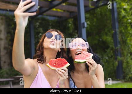 Zwei junge Frauen genießen einen sonnigen Tag im Freien und machen ein Selfie Stockfoto