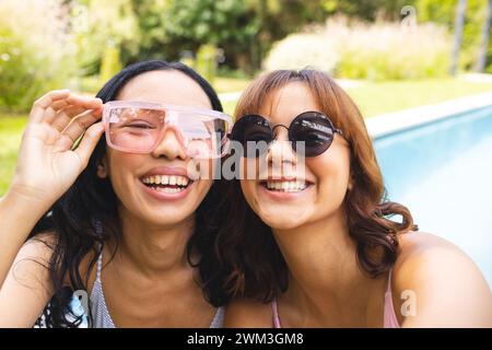 Birassische Freundinnen lächeln fröhlich draußen Stockfoto