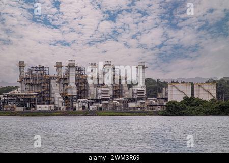 Limon Bay, Colon, Panama - 24. Juli 2023: AES Colon Kraftwerk oder Termoelectrica, Stromerzeugungstürme und technische Anlagen unter b Stockfoto