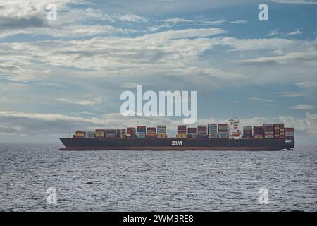 Limon Bay, Colon, Panama - 24. Juli 2023: Geladenes und verankertes ZIM-Containerschiff vor dem Hafen unter blauer Wolkenlandschaft Stockfoto