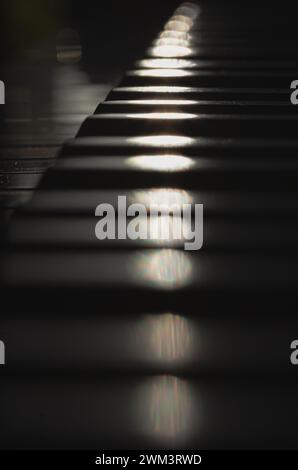 Hintergrund der Tastatur des Grand Piano. Seitenansicht der Klaviertasten mit geringer Schärfentiefe, Kopierraum, selektivem Fokus. Stockfoto