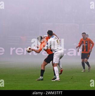 Hamburg – 15. Februar 2024: Danylo Sikan von Shakhtar Donetsk (in Orange) kämpft im Volksparkstadion um einen Ball mit Leonardo Balerdi aus Marseille Stockfoto