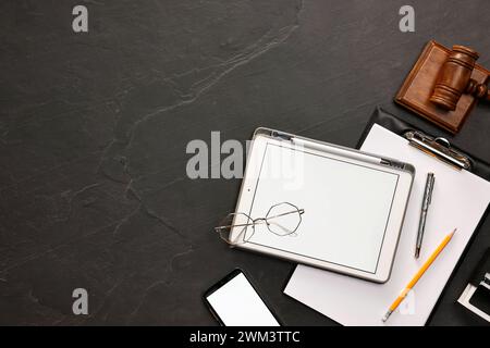 Flache Lay-Komposition mit modernem Tablet auf dunkelgrauem, strukturiertem Tisch. Leerzeichen für Text Stockfoto