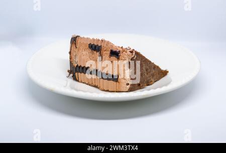 Kleines Stück Schokoladenkuchen, köstlicher Geschmack, braune Farbe auf weißem Hintergrund Stockfoto