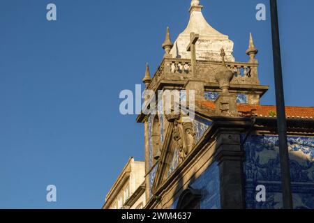 Turm der Kapelle der Seelen oder Capela das Almas mit wunderschönen blau-weißen Azulejo-Fliesen Fassade beleuchtet von goldenem Sonnenlicht in Porto, Portugal Stockfoto