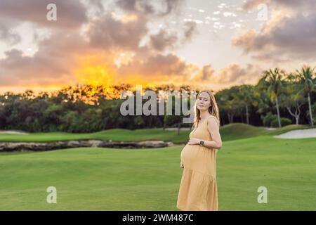 Ruhige Szene, in der eine schwangere Frau friedliche Momente im Park genießt, die Ruhe der Natur genießt und während ihrer Schwangerschaft Trost findet Stockfoto