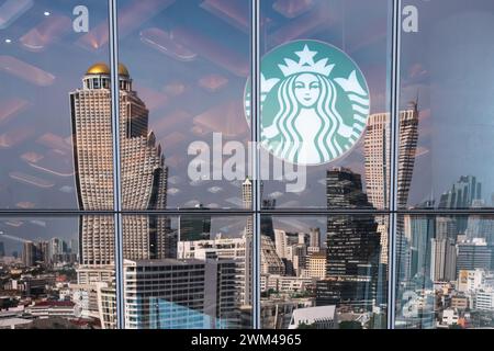 Logo von Starbucks mit dem Spiegelbild der Innenstadt im Starbucks im Einkaufszentrum Iconsiam am am 2. September 2023 in Bangkok, Thailand. Stockfoto