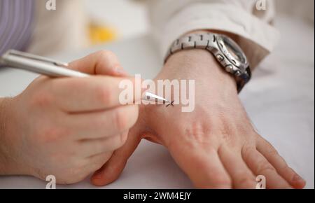 Männliche machen x Kreuz Hinweis mit Silber pen an seinem Arm für Bedenken in Nahaufnahme. Versuchen Sie, nicht zu vergessen zu tun Liste Konzept Stockfoto