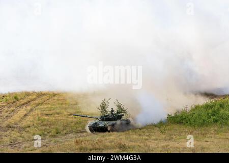 Schwere Kampffahrzeuge fahren um die Hintern und stellen einen Rauchschutz auf Stockfoto