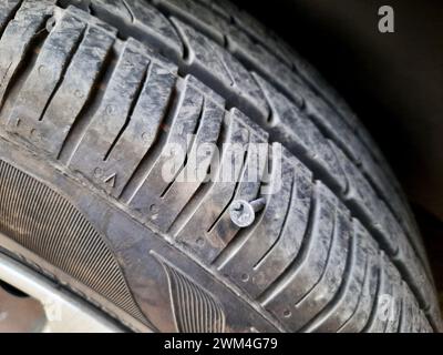Alte rostige Schraube oder Nagel in einem Autoreifen, die einen Schaden verursacht hat, und der Reifen muss repariert oder ersetzt werden, Servicekonzept für Automechaniker, Reifenspitze mit Stockfoto