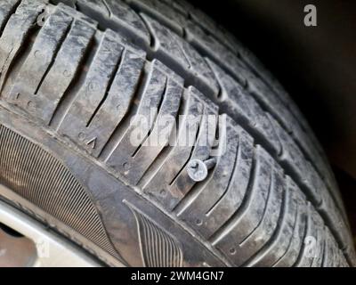 Alte rostige Schraube oder Nagel in einem Autoreifen, die einen Schaden verursacht hat, und der Reifen muss repariert oder ersetzt werden, Servicekonzept für Automechaniker, Reifenspitze mit Stockfoto