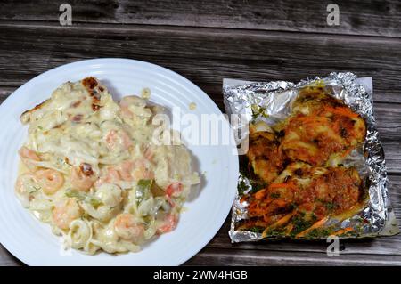 Gebackene cremige Meeresfrüchte gebackene Mischung aus Garnelen, Tintenfisch-Calamari, Fischfilet, Mozzarella-Käse, farbigen Paprika-Scheiben und gegrilltem Fischfilet W Stockfoto