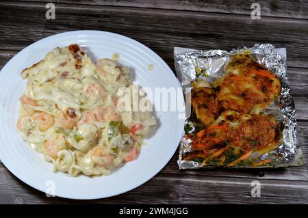 Gebackene cremige Meeresfrüchte gebackene Mischung aus Garnelen, Tintenfisch-Calamari, Fischfilet, Mozzarella-Käse, farbigen Paprika-Scheiben und gegrilltem Fischfilet W Stockfoto