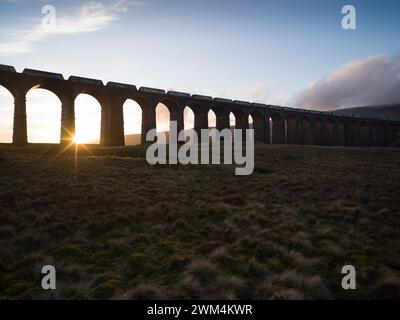 Ein Güterzug, der über den Ribblehead Viaduct auf der Siedler-Carlisle-Eisenbahnstrecke in North Yorkshire, England, fährt Stockfoto