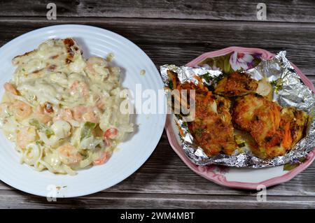 Gebackene cremige Meeresfrüchte gebackene Mischung aus Garnelen, Tintenfisch-Calamari, Fischfilet, Mozzarella-Käse, farbigen Paprika-Scheiben und gegrilltem Fischfilet W Stockfoto