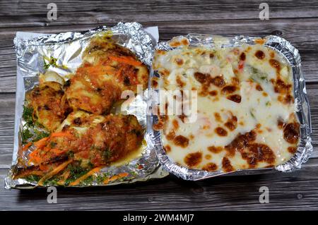 Gebackene cremige Meeresfrüchte gebackene Mischung aus Garnelen, Tintenfisch-Calamari, Fischfilet, Mozzarella-Käse, farbigen Paprika-Scheiben und gegrilltem Fischfilet W Stockfoto