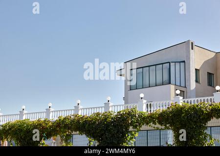 Fragment der Terrasse mit Säulen, Lampen und Geländern. Geländer aus weißem Stein oder Marmor mit Säulen, Balustern und Handläufen Stockfoto