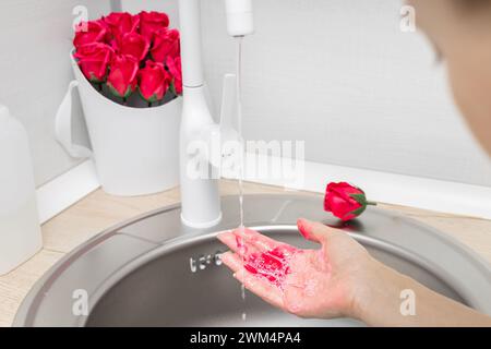 Die Frau wäscht sich die Hände mit Seifenblume. Strauß von Rosen aus Seife. Seifenblumen. Rose aus Seife. Hochwertige Fotos Stockfoto