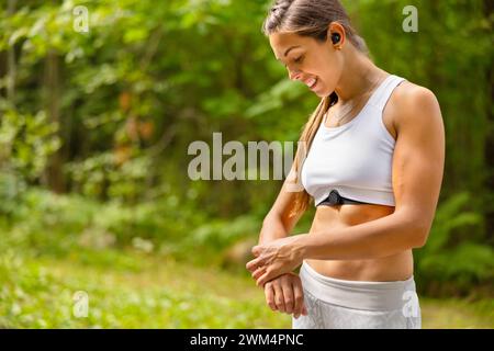 Gut ausgebildete Frau mit Fitness Smart Watch Gerät während des Trainings Stockfoto