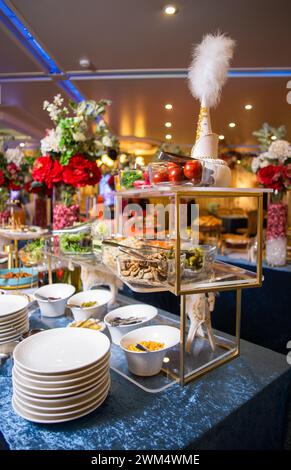 Genießen Sie eine köstliche Auswahl an Salaten, Gemüse und Snacks, die kunstvoll auf einem Buffet-Tisch präsentiert werden. Perfekt für Veranstaltungen, Partys oder Versammlungen. Iso Stockfoto