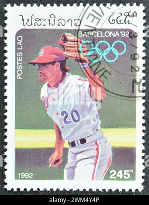 Gestempelte Briefmarke von Laos, die Baseball, Olympische Sommerspiele 1992 - Barcelona, um 1991 zeigt. Stockfoto