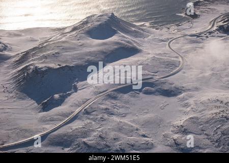 Kurvige Straße durch eine Winterlandschaft entlang der Südküste Islands westlich von Grindavik Stockfoto