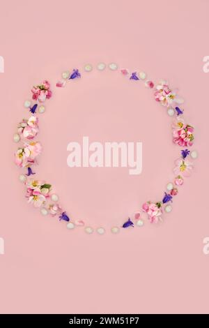 Blumenkranz zu Ostern mit Mini-Eiern, Blumenkranz und Apfelblüte. Abstraktes Design für Karte, Logo, Geschenkanhänger oder Einladung auf rosa Hintergrund Stockfoto