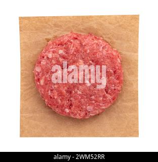 Frisches rohes Fleisch Burgerschnitzel auf Pergamentpapier isoliert auf weißem Hintergrund mit Schnittpfad, Draufsicht Stockfoto
