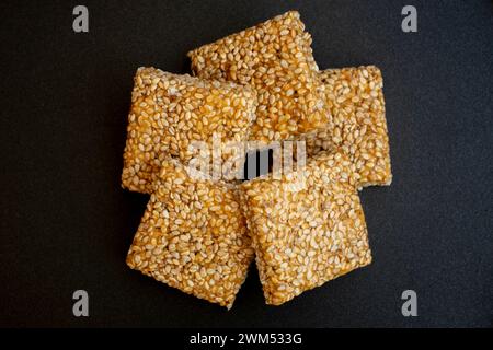 Bis Chikki auf schwarzgrauem Hintergrund. Till Chikki ist ein indisches Süßwarengericht, das mit Jaggery und Sesam zubereitet wird. Indisches Festival makar sankranti besonderes Süßes Stockfoto