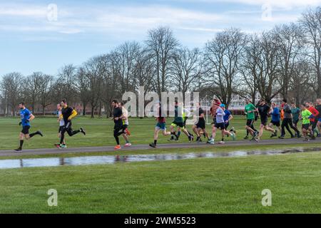 Teilnehmer am Rushmoor Parkrun, einem regulären Samstag-Laufrennen in Aldershot, Hampshire, England, im Februar 2024 Stockfoto