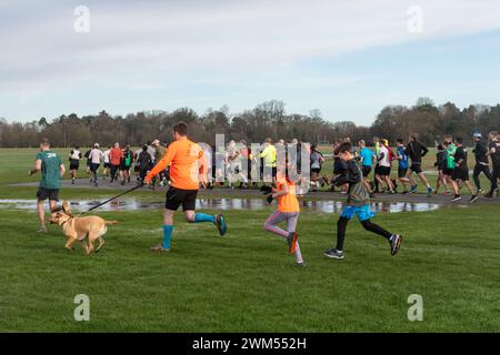 Teilnehmer am Rushmoor Parkrun, einem regulären Samstag-Laufrennen in Aldershot, Hampshire, England, im Februar 2024 Stockfoto