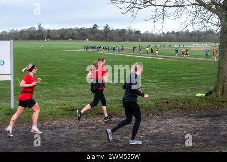 Teilnehmer am Rushmoor Parkrun, einem regulären Samstag-Laufrennen in Aldershot, Hampshire, England, im Februar 2024. Frauen im Sport. Stockfoto