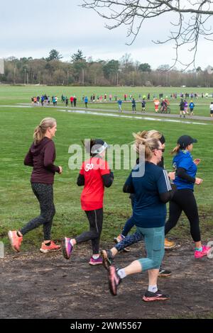 Teilnehmer am Rushmoor Parkrun, einem regulären Samstag-Laufrennen in Aldershot, Hampshire, England, im Februar 2024. Frauen im Sport. Stockfoto