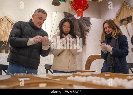 Peking, Laternenfest im Bezirk Rongchang in der südwestlichen chinesischen Gemeinde Chongqing. Februar 2024. Ausländische Touristen machen Tangyuan, oder süße, klebrige Reisknödel, während einer Veranstaltung, die das Laternenfest im Bezirk Rongchang der südwestlichen chinesischen Gemeinde Chongqing am 24. Februar 2024 feiert. Die Menschen im ganzen Land feiern das Laternenfest, das am 24. Februar dieses Jahres in einer festlichen und geschäftigen Atmosphäre stattfand. Quelle: Tang Yi/Xinhua/Alamy Live News Stockfoto