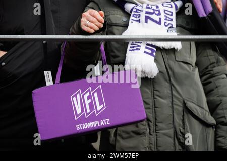 24. Februar 2024, Niedersachsen, Osnabrück: Fußball: Bundesliga 2, VfL Osnabrück - Hannover 96, Spieltag 23 im Stadion Bremer Brücke. Ein Osnabrücker Fan hält ein Sitzkissen („Stammplatz“). Foto: Friso Gentsch/dpa - WICHTIGER HINWEIS: Gemäß den Vorschriften der DFL Deutschen Fußball-Liga und des DFB Deutschen Fußball-Bundes ist es verboten, im Stadion und/oder im Spiel aufgenommene Fotografien in Form von sequenziellen Bildern und/oder videoähnlichen Fotoserien zu verwenden oder zu verwenden. Stockfoto