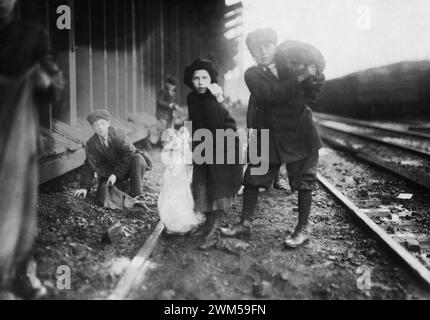 Kleine Kinder, die Kohle vom Eisenbahnkohlebahnhof in Boston, Massachusetts stehlen. Foto von Lewis W. Hine Stockfoto