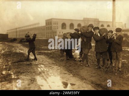 Kleine Kinder, die Kohle vom Eisenbahnkohlebahnhof stehlen. Boston, Massachusetts. Foto von Lewis W. Hine – Sepia-Version Stockfoto