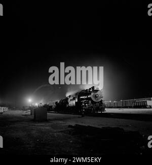 Zug mit Lokomotive im Dunkeln - Barstow, Kalifornien. Blick auf Atchison, Topeka und Santa Fe Railroad Hof bei Nacht - Jack Delano Foto, 1943 Stockfoto
