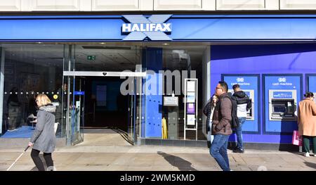 Am 24. Februar 2024 laufen die Menschen an der Niederlassung der Halifax Bank in Piccadilly, Manchester, UK, vorbei. Am 22. Februar überraschte die Halifax Bank den Markt mit einer Senkung der Hypothekenzinsen, nachdem die meisten Kreditgeber die Hypothekenpreise erhöht hatten. Stockfoto