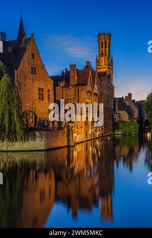 Belgische Stadt Brügge nach Sonnenuntergang. Der Kanal am Rosenkranz in der Hansestadt. Reflexionen auf der Wasseroberfläche mit historischen Gebäuden. Beleuchtetes Ol Stockfoto