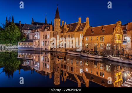 Beleuchtete Häuser am Kanal in Brügge am Abend. Rosary Quay im Zentrum der Altstadt der Hansestadt zur blauen Stunde. Stockfoto