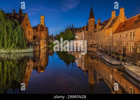 Brügge Kanal am Abend. Rosary Quay im Zentrum der Altstadt der Hansestadt. Beleuchtete historische Kaufmannshäuser mit Reflexionen Stockfoto