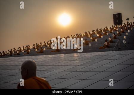 Mönche beten während der jährlichen Zeremonie von Makha Bucha im Wat Dhammakaya im Norden von Bangkok. Die Thailänder feiern das buddhistische fest der Umgehungsbewegung im Uhrzeigersinn und die Makha Bucha Laternen-Lichtzeremonie am „Makha Bucha Day“ während des dritten Mondmondes, wo sich etwa 5000 Mönche versammelten, um vom Buddha geweiht zu werden, und 35000 Gläubige, die Laternen halten. (Foto: Guillaume Payen / SOPA Images/SIPA USA) Stockfoto
