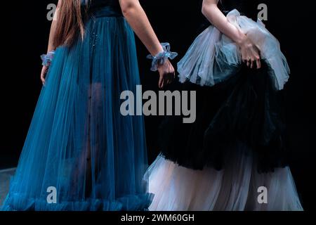 Lange flauschige Abendkleider in Blau und weiß auf weiblichen Figuren auf schwarzem Hintergrund. Modenschau-Details Stockfoto