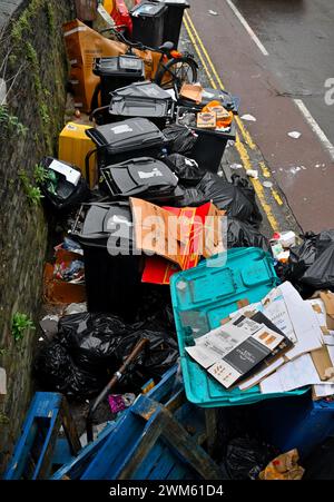 Volle, überfüllte Abfallbehälter und fliegende Abfälle an der Stadtstraße, Bristol, Großbritannien Stockfoto