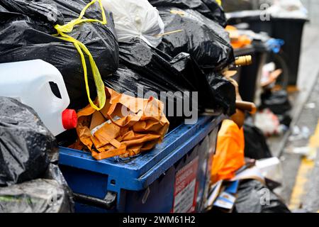 Volle, überfüllte Abfallbehälter und fliegende Abfälle an der Stadtstraße, Bristol, Großbritannien Stockfoto