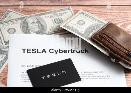 Augsburg, Bayern, Deutschland - 24. Februar 2024: Dollar-Banknoten mit Tesla Fahrzeugkarte und Schriftzug: Tesla Cybertruck *** Dollar Geldscheine mit einer Tesla Fahrzeugkarte und dem Schriftzug: Tesla Cybertruck Stockfoto